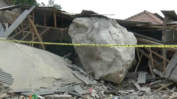Batu yang menimpa rumah warga