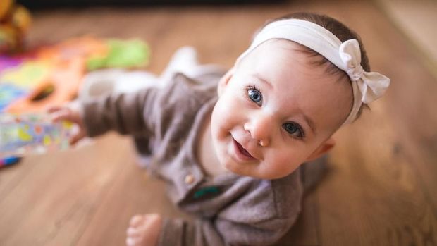 Adorable Baby Girl Learning How To Crawl At Her Warm Home