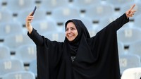 Tampak perempuan Iran berswafoto di dalam stadion, mengabadikan momen yang terbilang langka. Tahun lalu pemerintah Iran sempat mengizinkan perempuan masuk stadion, namun kemudian dilarang lagi. (Foto: Amin M. Jamali/Getty Images)