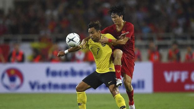 Vietnam's Nguyen Tuan Anh (R) fights for the ball with Malaysia's Mohamad Aidil Zafuan (L) during the Qatar 2022 World Cup qualifying football match between Vietnam and Malaysia at the My Dinh stadium in Hanoi on October 10, 2019. (Photo by Manan VATSYAYANA / AFP)
