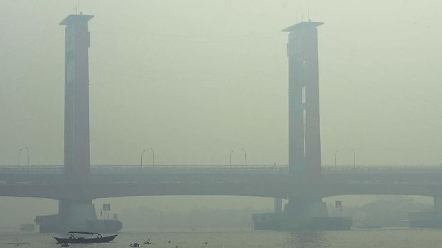 KABUT ASAP DI PALEMBANG Warga beraktivitas di perairan Sungai Musi yang tertutup kabut asap di Palembang, Sumatera Selatan, Jumat (11/10/2019). Sejumlah wilayah di Palembang masih diselimuti kabut asap dampak dari kebakaran hutan dan lahan yang terjadi di sejumlah kawasan di Sumatera Selatan. ANTARA FOTO/Mushaful Imam/Lmo/foc.