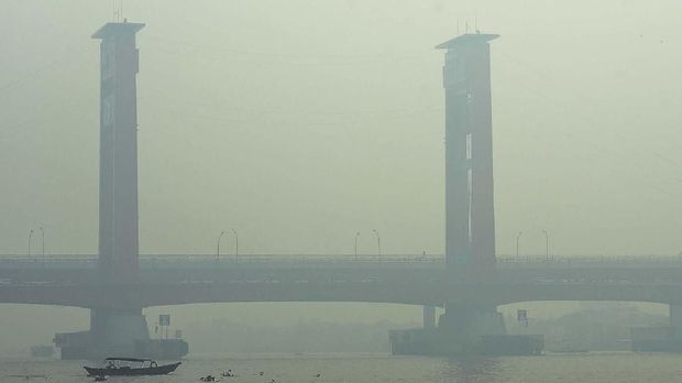 Warga beraktivitas di perairan Sungai Musi yang tertutup kabut asap di Palembang, Sumatera Selatan, Jumat (11/10/2019). Sejumlah wilayah di Palembang masih diselimuti kabut asap dampak dari kebakaran hutan dan lahan yang terjadi di sejumlah kawasan di Sumatera Selatan. ANTARA FOTO/Mushaful Imam/Lmo/foc.