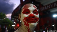Ada juga suporter yang merias wajahnya seperti badut.