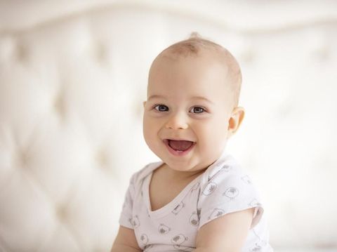 Beautiful baby on white towel is looking at camera, horiztonal