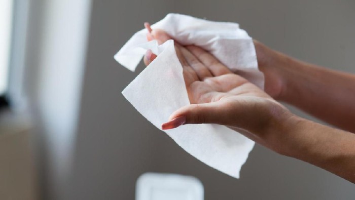 Tisu magic Young woman cleaning fingers and hands with wet wipes