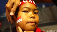 Para suporter datang dengan beragam gaya. Seorang suporter ini hadir dengan pipi yang dihiasi dengan bendera merah putih. Dia juga memakai ikat kepada bertuliskan Indonesia.