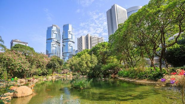 Hong Kong Park, Hong Kong Beautiful view of pond at the lush Hong Kong Park surrounded by skyscrapers in the Central business district in Hong Kong island. Sunny day with blue sky.