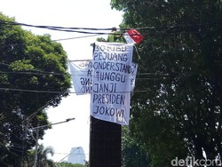 Pria Ini Panjat Beton di Belakang DPR, Kibarkan Spanduk Tagih Janji Jokowi