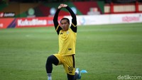 Seorang pemain tengah melakukan pemanasan.