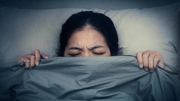 Side view portrait of a insomniac girl unable to sleep in the night on a bed