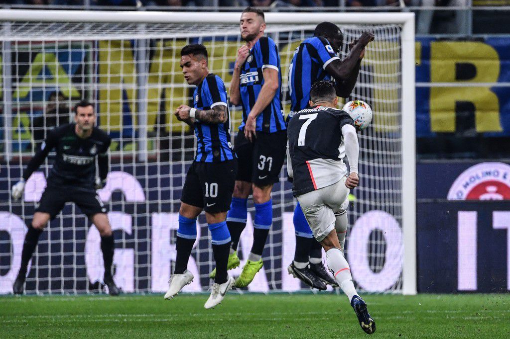 Juventus' Portuguese forward Cristiano Ronaldo (Front R) shoots a free kick during the Italian Serie A football match Inter vs Juventus on October 6, 2019 at the San Siro stadium in Milan. (Photo by Alberto PIZZOLI / AFP)
