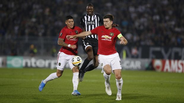Partizan's Umar Sadiq, center, tries to get past Manchester United's Marcos Rojo, left, and Harry Maguire during their Europa League group L soccer match at the Partizan stadium in Belgrade, Serbia, Thursday, Oct. 24, 2019. (AP Photo/Marko Drobnjakovic)