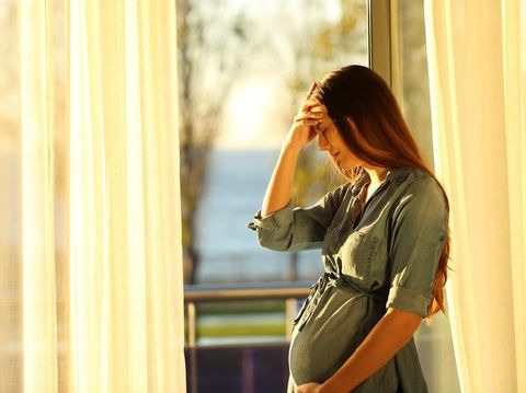 Worried pregnant woman complaining at home