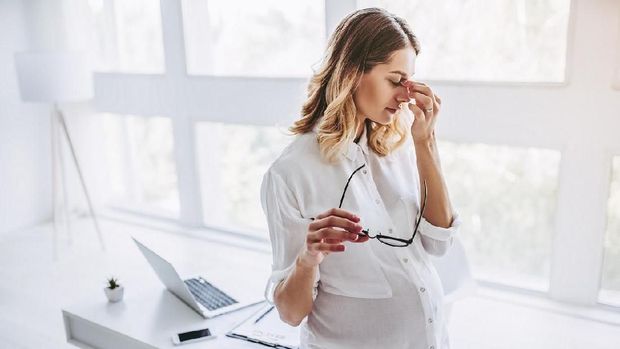 Worried pregnant woman complaining at home