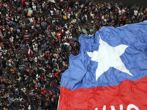 People gather during an anti-government protest in Santiago, Chile, Friday, Oct. 25, 2019. At least 19 people have died in the turmoil that has swept the South American nation. The unrest began as a protest over a 4-cent increase in subway fares and soon morphed into a larger movement over growing inequality in one of Latin America's wealthiest countries. (AP Photo/Rodrigo Abd)