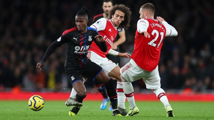 LONDON, ENGLAND - OCTOBER 27: Wilfried Zaha of Crystal Palace battles for possession with Matteo Guendouzi and Calum Chambers of Arsenal during the Premier League match between Arsenal FC and Crystal Palace at Emirates Stadium on October 27, 2019 in London, United Kingdom. (Photo by Catherine Ivill/Getty Images)