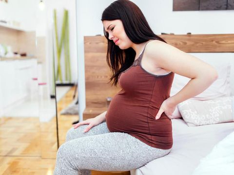 Pregnant woman having back aches  in the last trimester of pregnancy