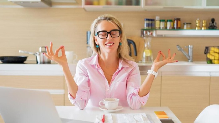 zodiak Young woman looking at bills while sitting on floor managing home budget