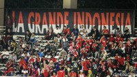 Pendukung Timnas meneriakan yel-yel.