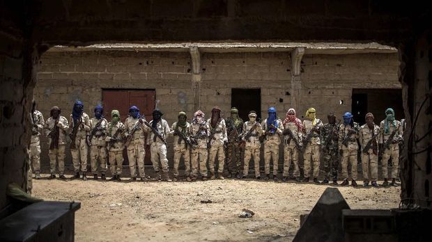 A group of Fulani militiamen pose for a picture with their weapons on July 6, 2019, at an informal demobilisation camp in Sevare run by Sekou Bolly, a local Fulani businessman whose goal is to take away young Fulani from the morse of jihadism. (Photo by Marco LONGARI / AFP)