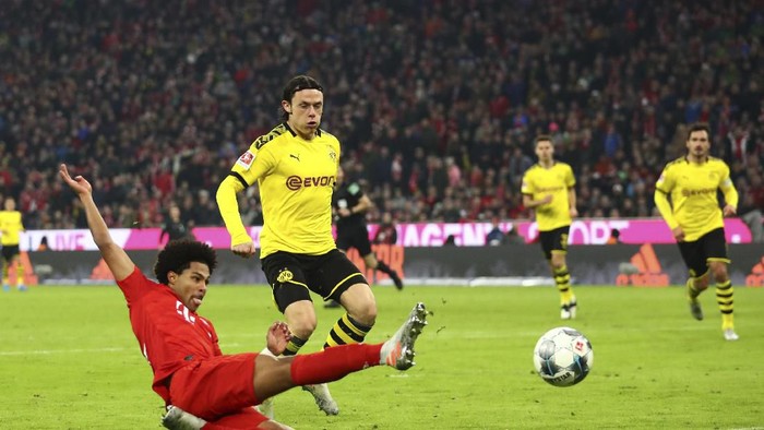 Bayerns Robert Lewandowski, right, scores his sides opening goal during the German Bundesliga soccer match between FC Bayern Munich and Borussia Dortmund, in Munich, Germany, Saturday, Nov. 9, 2019. (AP Photo/Matthias Schrader)