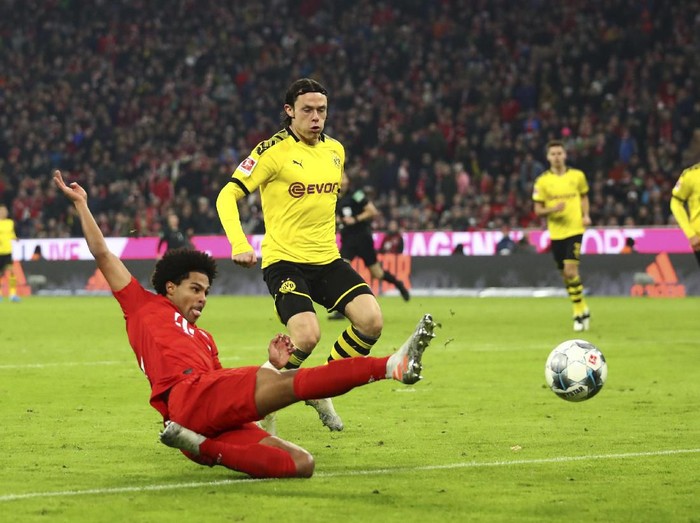 Bayerns Robert Lewandowski, right, scores his sides opening goal during the German Bundesliga soccer match between FC Bayern Munich and Borussia Dortmund, in Munich, Germany, Saturday, Nov. 9, 2019. (AP Photo/Matthias Schrader)