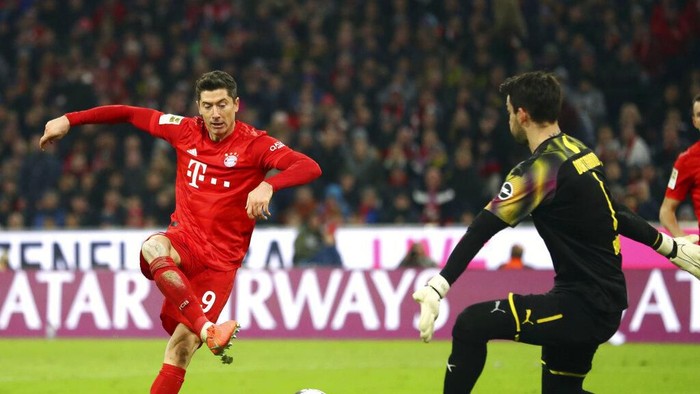 Bayerns Robert Lewandowski, right, scores his sides opening goal during the German Bundesliga soccer match between FC Bayern Munich and Borussia Dortmund, in Munich, Germany, Saturday, Nov. 9, 2019. (AP Photo/Matthias Schrader)