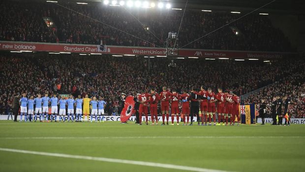Manchester City and Liverpool teams stand for a minute of silence for the Remembrance Day, during the English Premier League soccer match between Liverpool and Manchester City at Anfield stadium in Liverpool, England, Sunday, Nov. 10, 2019. (AP Photo/Jon Super)