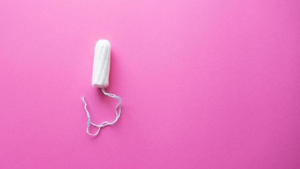 Menstrual cycle, feminine care, menstruation and intimate products concept with internal tampon isolated on pink background with copy space