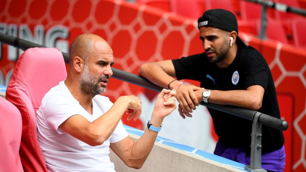 Riyad Mahrez berdiskusi dengan Josep Guardiola. (Foto: Clive Mason/Getty Images)