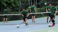 Pemain berlatih ringan seperti menggiring bola menyundul di lapangan tenis.