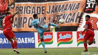 Delvin Rumbino yang mendapat pengawalan ketat berusaha melepaskan tendangan. Dalam pertandingan ini, pemain dengan nomor punggung 99 itu berhasil membobol gawang Persija di menit ke-43.