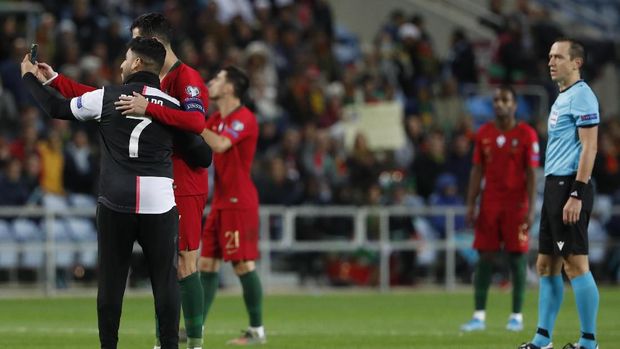 Cristiano Ronaldo menyempatkan diri berfoto bersama seorang penyusup.