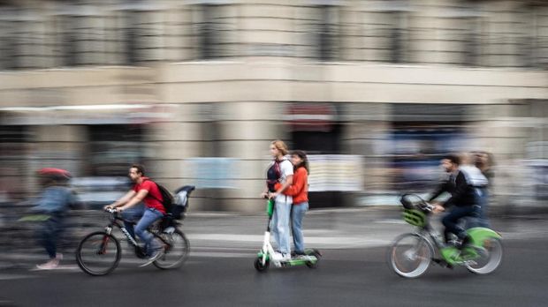 (FILES) In this file photo taken on September 13, 2019 a couple rides an electric scooter in Paris. (Photo by Martin BUREAU / AFP)