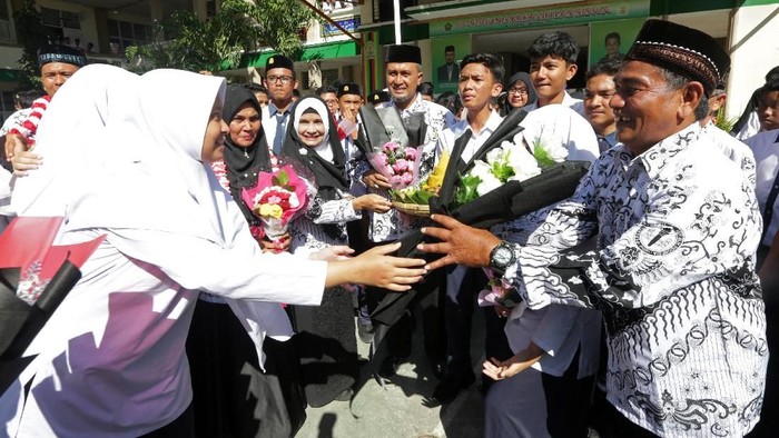 Pelajar memberikan bunga pada gurunya seusai upacara peringatan hari guru nasional dan dan HUT Persatuan Guru Republik Indonesia (PGRI) di MTsN Model, Banda Aceh, Aceh, Senin (25/11/2019). Peringatan hari guru nasional yang bertepatan dengan HUT ke-74 PGRI menjadi momentum memberikan penghargaan dan ungkapan terima kasih kepada guru yang telah mendidik serta meningkatkan kualitas sumber daya manusia generasi penerus pembangunan bangsa. ANTARA FOTO/Irwansyah Putra/foc.