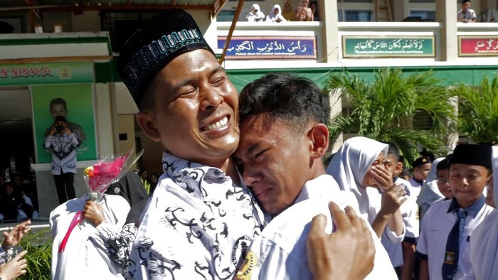 PERINGATAN HARI GURU DAN PGRI Pelajar memberikan ucapan selamat dengan memeluk gurunya seusai upacara peringatan hari guru nasional dan HUT Persatuan Guru Republik Indonesia (PGRI) di MTsN Model, Banda Aceh, Aceh, Senin (25/11/2019). Peringatan hari guru nasional yang bertepatan dengan HUT ke-74 PGRI menjadi momentum memberikan penghargaan dan ungkapan terima kasih kepada guru yang telah mendidik serta meningkatkan kualitas sumber daya manusia generasi penerus pembangunan bangsa. ANTARA FOTO/Irwansyah Putra/foc.