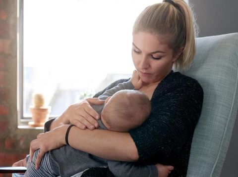 Young mother breastfeeding at home, bonding with baby child toddler