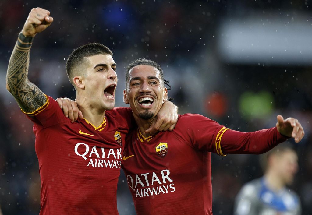 Roma's Gianluca Mancini, left, celebrates with his teammate Chris Smalling after scoring his side's second goal, during the Serie A soccer match between Roma and Bresciaat the Olympic stadium stadium in Rome, Sunday, Nov. 24, 2019. (Riccardo Antimiani/ANSA via AP)
