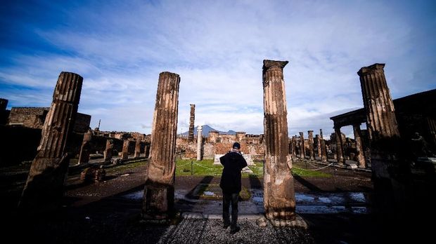 situs bersejarah pemandian air panas pompeii A visitor views the Sanctuary of Apollo on November 25, 2019 in Pompeii. - Recent digs at Pompeii have offered up several impressive finds, including an inscription uncovered last year that proves the city near Naples was destroyed after October 17, 79 AD, and not on August 24 as thought. (Photo by Filippo MONTEFORTE / AFP) / TO GO WITH AFP STORY BY ELLA IDE