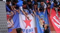 Tampak para suporter berusaha berjabat tangan dengan pelatih dan pemain Arema FC dari atas tribune. 