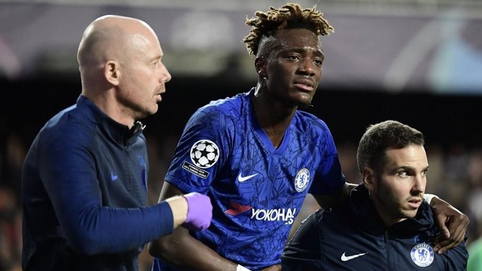 Chelseas English striker Tammy Abraham is helped after resulting injured during the UEFA Champions League Group H football match between Valencia CF and Chelsea FC at the Mestalla stadium in Valencia on November 27, 2019. (Photo by JAVIER SORIANO / AFP)