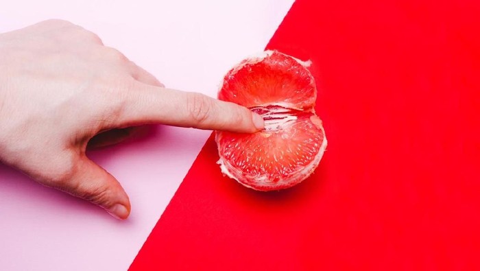 miss v vagina selaput dara Concept sex, masturbation. Hand, fingers in grapefruit, vagina symbol on a red background