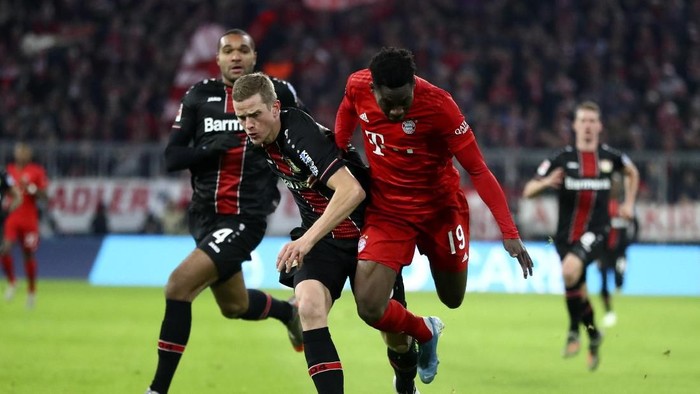 Bayerns Alphonso Davies, right, and Leverkusens Sven Bender challenge for the ball during the German Bundesliga first devision soccer match between FC Bayern Munich and bayer Leverkusen 04 in Munich, Germany, Saturday, Nov. 30, 2019. (AP Photo/Matthias Schrader)