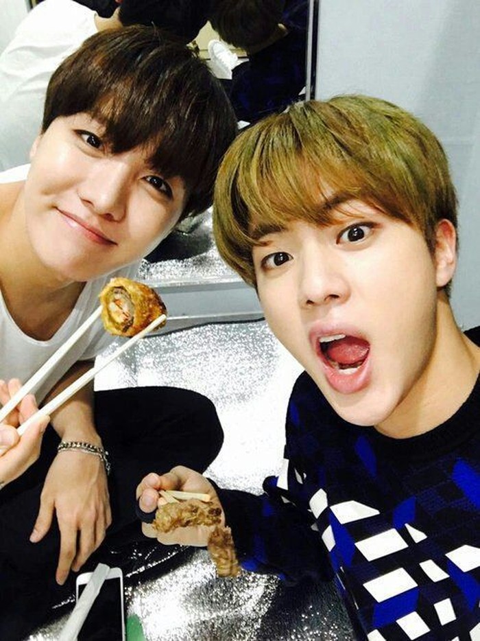 Dengan J-Hope, Jin pasang pose seru saat menyantap makanan kesukaan mereka dengan sumpit di sela-sela aktivitasnya yang padat. Foto: Twitter & Instagram BTS