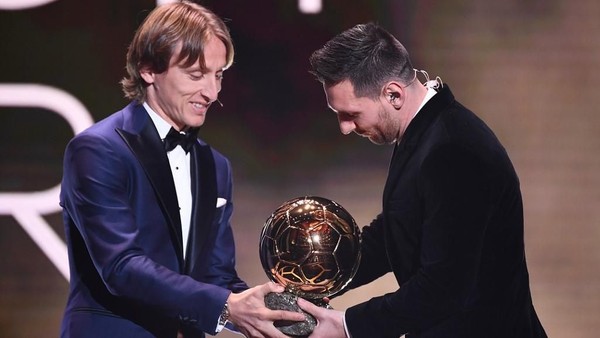 Luka Modric menyerahkan trofi Ballon dOr kepada Lionel Messi (Foto: FRANCK FIFE / AFP)