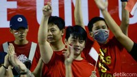 Para suporter kompak mengenakan busana serba merah.