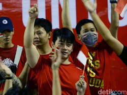 Para suporter kompak mengenakan busana serba merah.