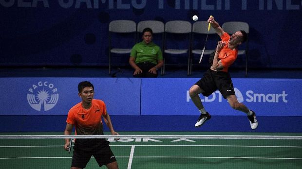 Ganda putra Indonesia Muhammad Rian Ardianto (kanan) dan Fajar Alfian mengembalikan kok ke arah ganda putra Malaysia Aaron Chia Teng Fong dan Soh Wooi Yik dalam final bulu tangkis beregu putra SEA Games 2019 di Kompleks Olahraga Muntinlupa, Manila, Filipina, Rabu (4/12/2019). Tim bulu tangkis beregu putra Indonesia meraih medali emas setelah mengalahkan Malaysia dengan skor 3-1. ANTARA FOTO/Sigid Kurniawan/ama.