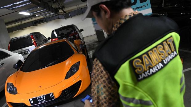 Sidak Pajak Mobil Mewah Petugas Samsat Jakarta Utara menunjukkan stiker 'Objek Pajak' di depan mobil mewah Bentley saat razia supervisi pencegahan pajak mobil mewah di Apartemen Regatta, Jakarta Utara di Jakarta, Kamis (5/12/2019). Badan Pajak dan Restribusi Daerah (BPRD) DKI Jakarta bekerja sama dengan Samsat Jakarta Utara dan Komisi Pemberantasan Korupsi (KPK) melakukan penindakan terhadap 11 mobil mewah yang menunggak pembayaran pajak. ANTARA FOTO/M Risyal Hidayat/wsj.