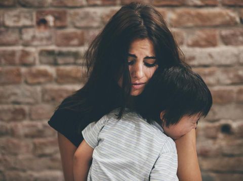 Mother holding little boy and crying, family violence